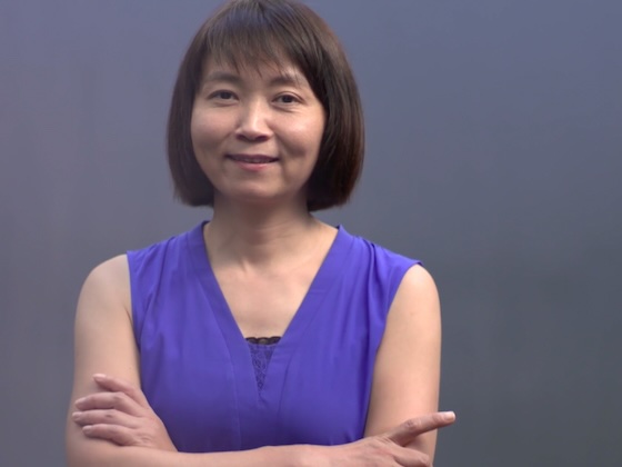 A woman with crossed arms smiles